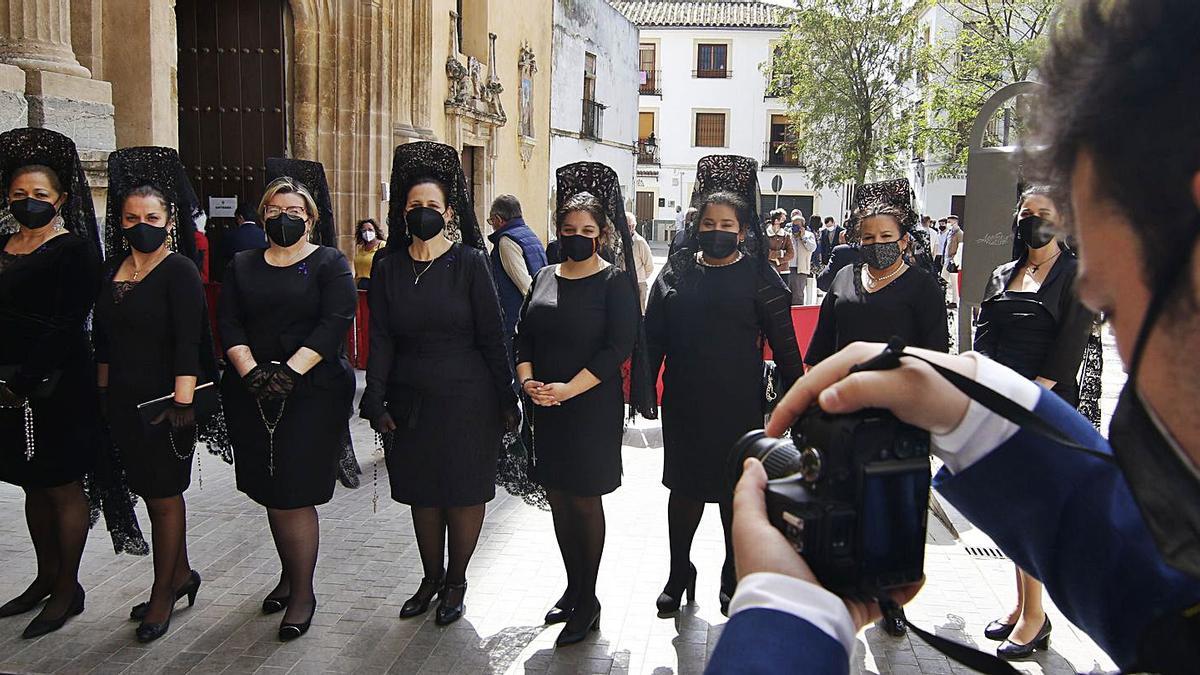 Grupo de mujeres vestidas con la tradicional mantilla ayer a las puertas de la iglesia de San Agustín.