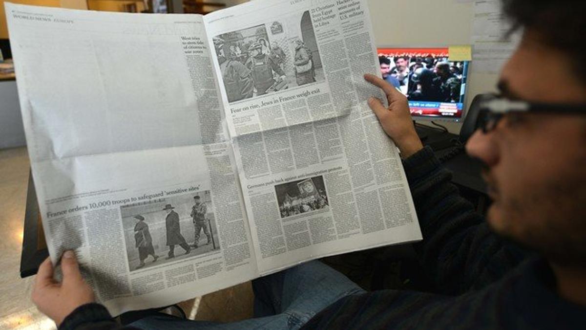 Un paquistaní lee la edición local de 'The New York Times', en la que ha sido eliminada la información sobre 'Charlie Hebdo', este miércoles en Islamabad.