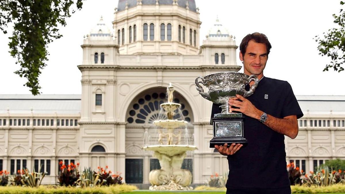 Roger Federer muestra hoy a la prensa australiana su trofeo.