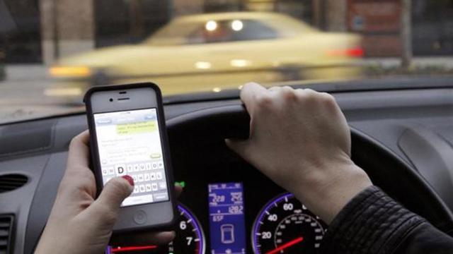Conductora usando el móvil al volante.