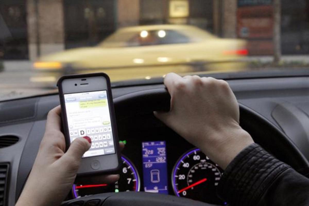 Conductora usando el móvil al volante.