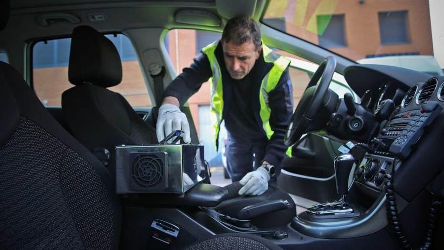 Rubén García, jefe de taller, utilizando uno de los dispositivos para desinfectar un coche policial.