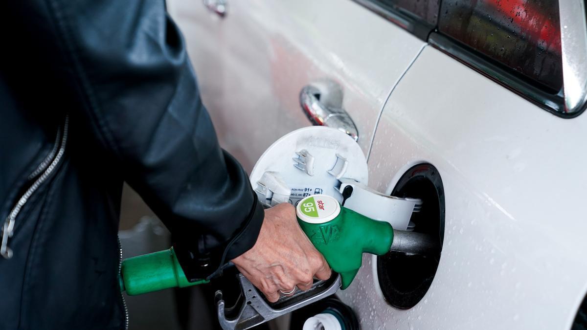 Una mujer pone gasolina a su vehículo en una gasolinera.