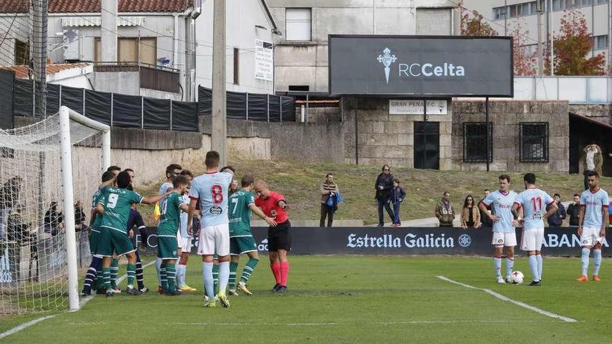 El árbitro coloca la barrera de jugadores del Coruxo tras castigar una cesión. // Alba Villar