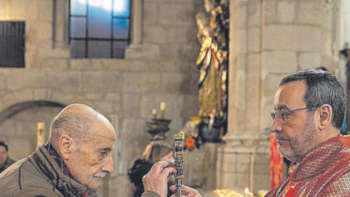 Un hombre adora la reliquia de San Blas