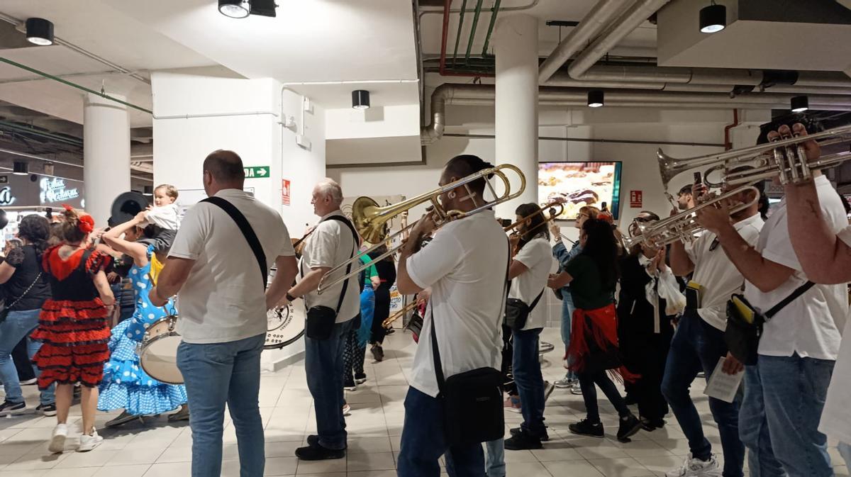 Una charanga toca en el interior del Mercado Central de Alicante, entre puestos y clientes