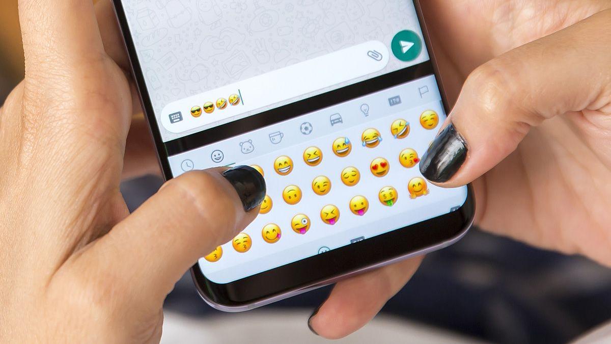 Una mujer utiliza 'emojis' en WhatsApp.