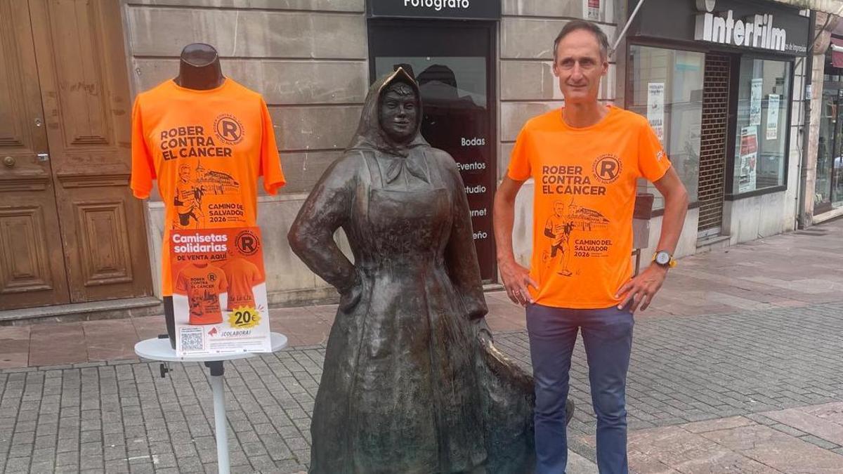 Nicolás de las Heras, con las camisetas solidarias, junto a la estatua de La Muyerina, en la plaza General Ponte de Grado.