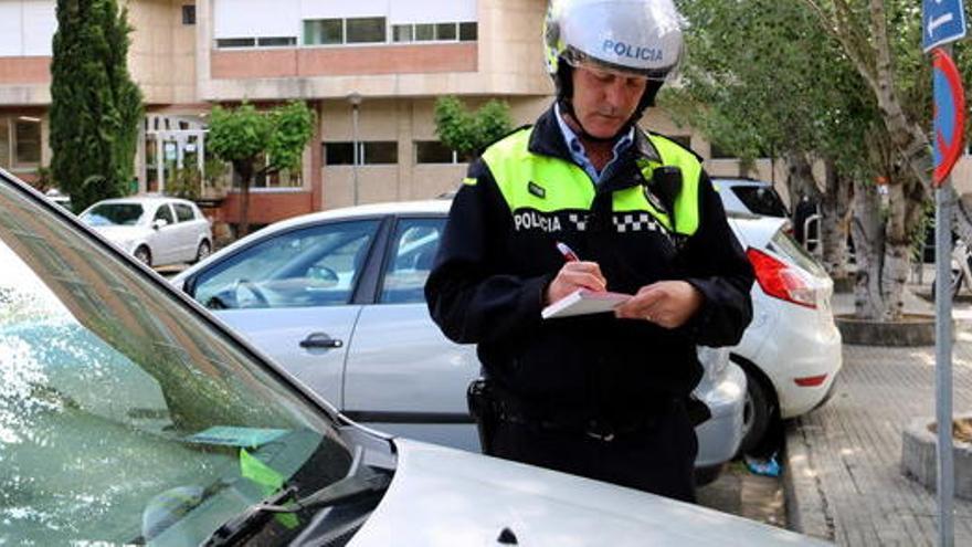 Un agent multa un vehicle que té la targeta de minusvàlids caducada.