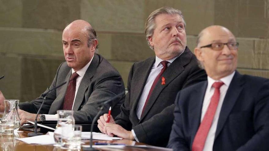 Por la izquierda, Luis de Guindos, Íñigo Méndez de Vigo y Cristóbal Montoro. // Efe