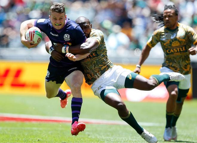 Max Mcfarland (L) de Escocia es abordado por Siviwe Soyzwapi (R) de Sudáfrica durante los cuartos de final entre Escocia y Sudáfrica en el segundo y último día del torneo de Rugby Sevens, en el estadio de Ciudad del Cabo.