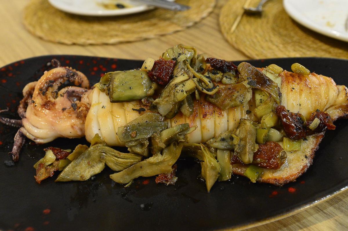 Calamar a la plancha con salteado de alcachofas y tomatitos secos.