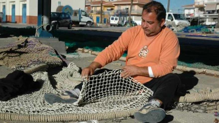 Un pescador muestra una de las nuevas redes reglamentarias.