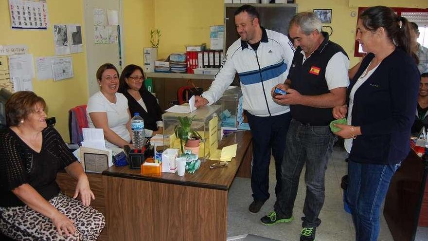 Unas personas depositan sus votos, ayer, en la cofradía de pescadores de Redondela.