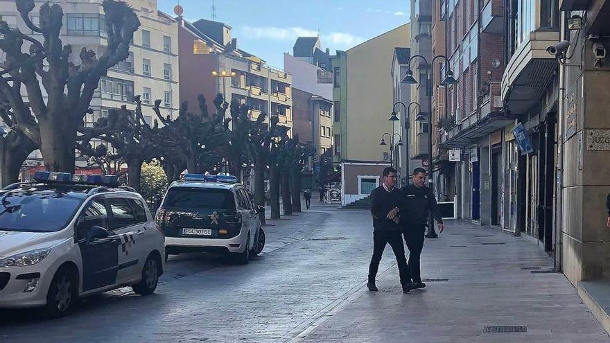 Pedro J., esposado y custodiado por un agente, cuando llegaba al Juzgado de Lena para declarar.