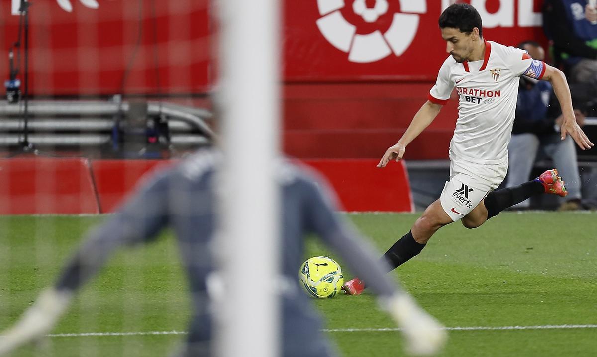 El lateral del Sevilla Jesús Navas se dispone a jugar un balón ante el portero Joel Robles, del Betis, durante el partido de Liga en Primera División disputado esta noche en el estadio Ramón Sánchez-Pizjuán, en Sevilla.