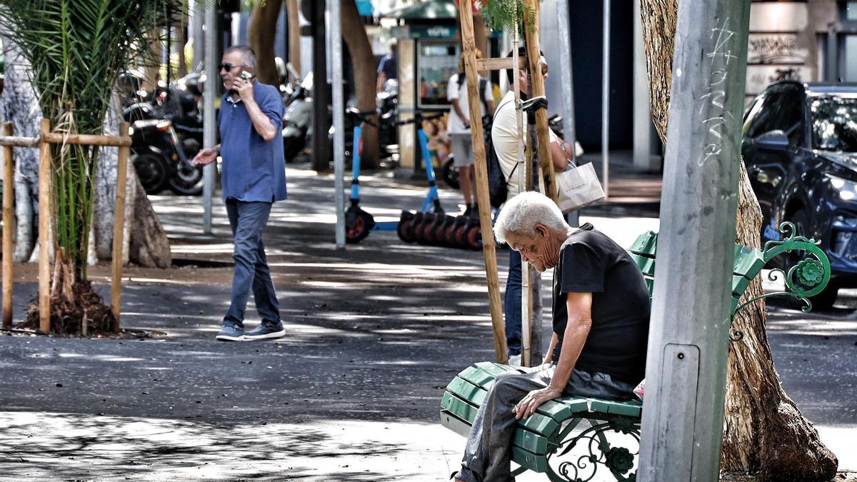 Una persona sin hogar, en un banco de Santa Cruz.