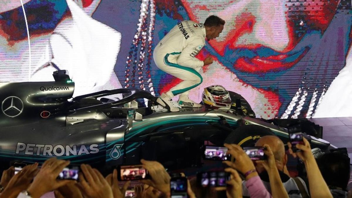 El britániico Lewis Hamilton celebra, frente a los mecánicos del equipo Mercedes, su triunfo de hoy en Singapur.