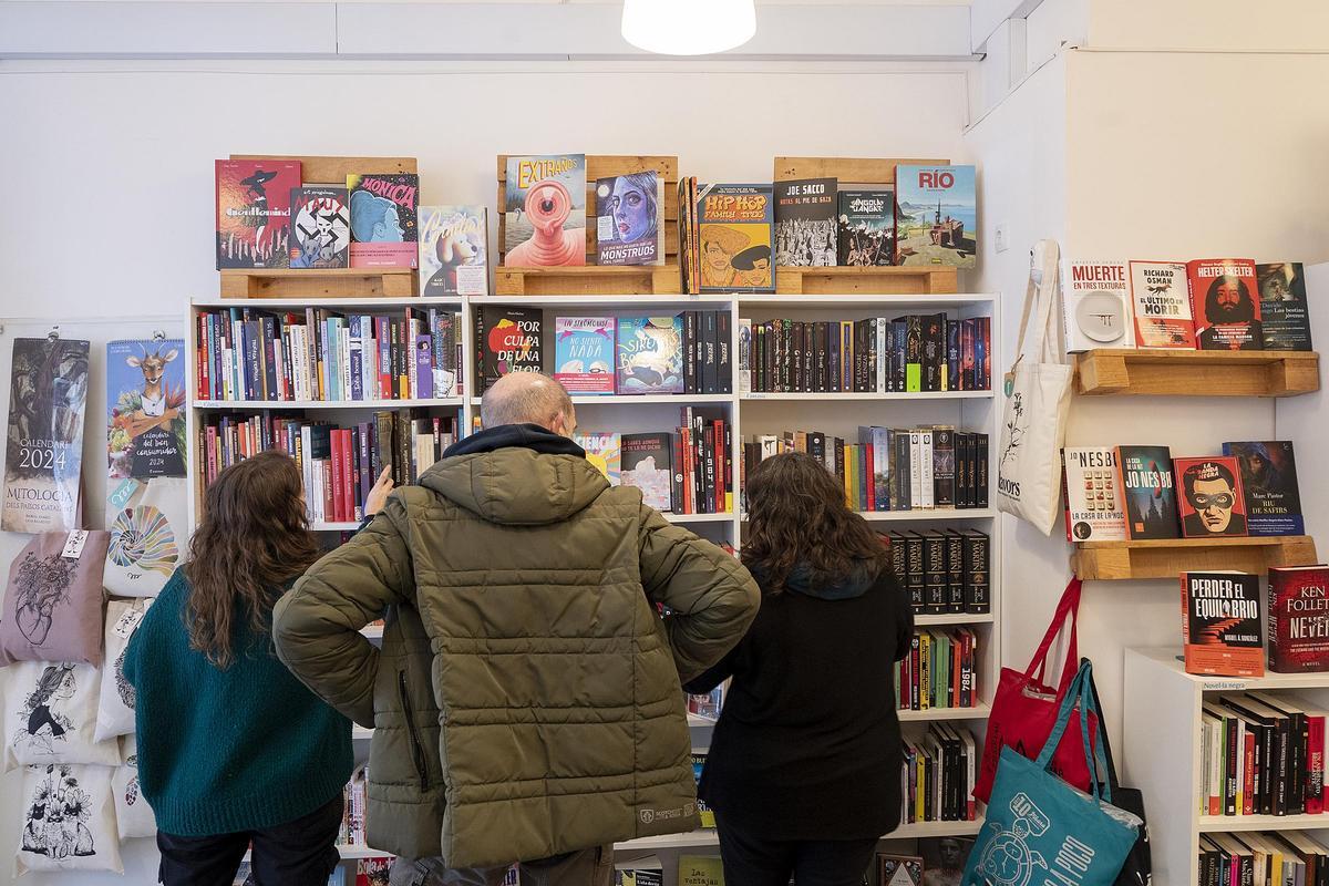 Alicia y Noelia, de la librería Llavors de L'Hospitalet, aconsejan a un cliente.