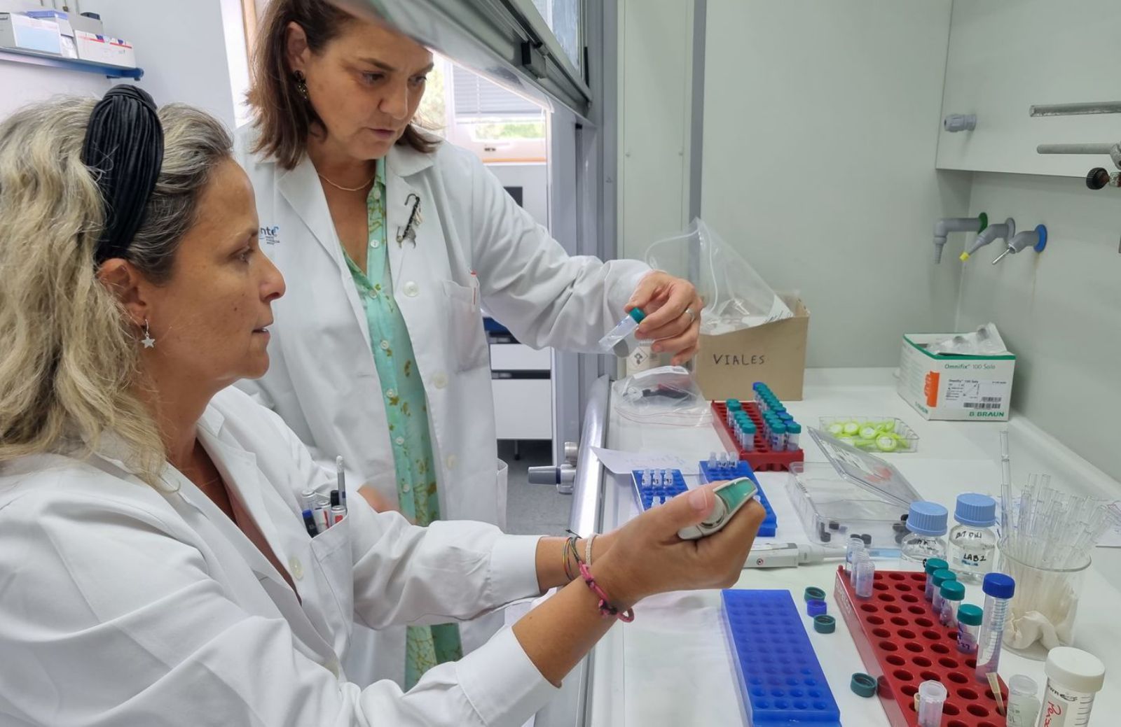 Covadonga Salgado (de pie) y una de las profesionales del lntecmar, en Vilagarcía, durante la realización de pruebas para determinar la evolución de la toxicidad.   | //  FDV