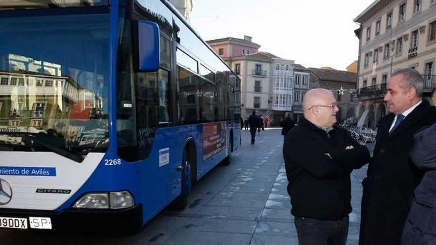 Francisco Fernández (de Autos Villa), Carlos González y Luis Fernández conversan en el Parche al lado de un autobús de la Compañía del Tranvía Eléctrico de Avilés.