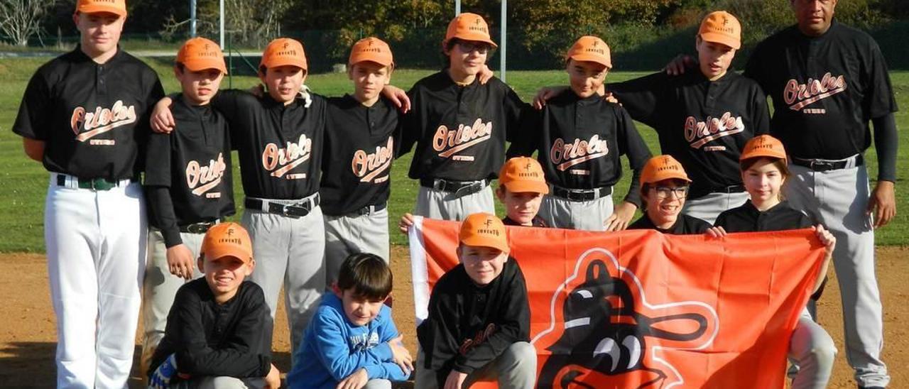 Los equipos infantil, con camiseta negra, y cadete de los Orioles de Oviedo, junto al preparador Enzo Contreras.