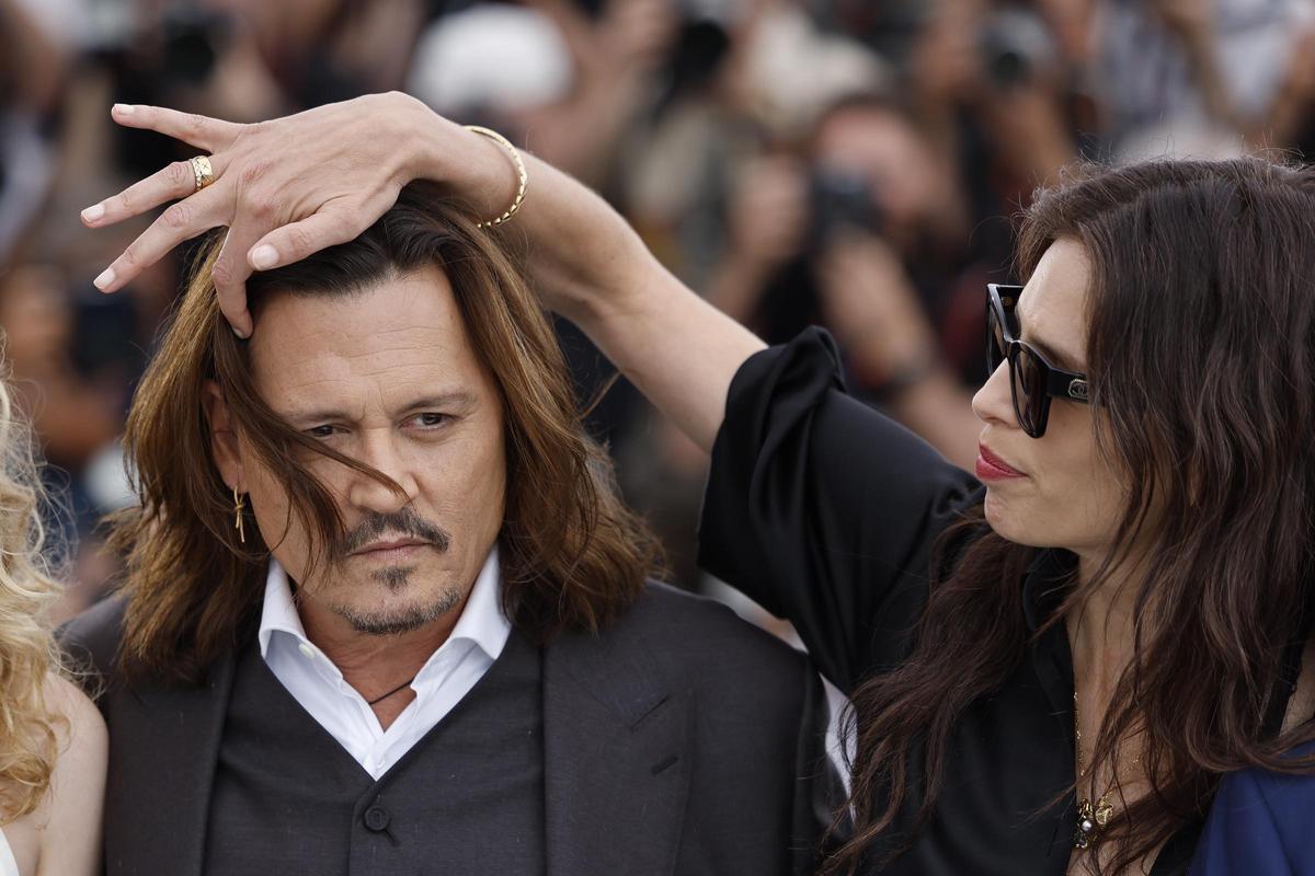 La directora y actriz Maïwenn aparta el pelo de la cara a Johnny Depp, en el pose ante la prensa de la presentación de la película "Jeanne du Barry".