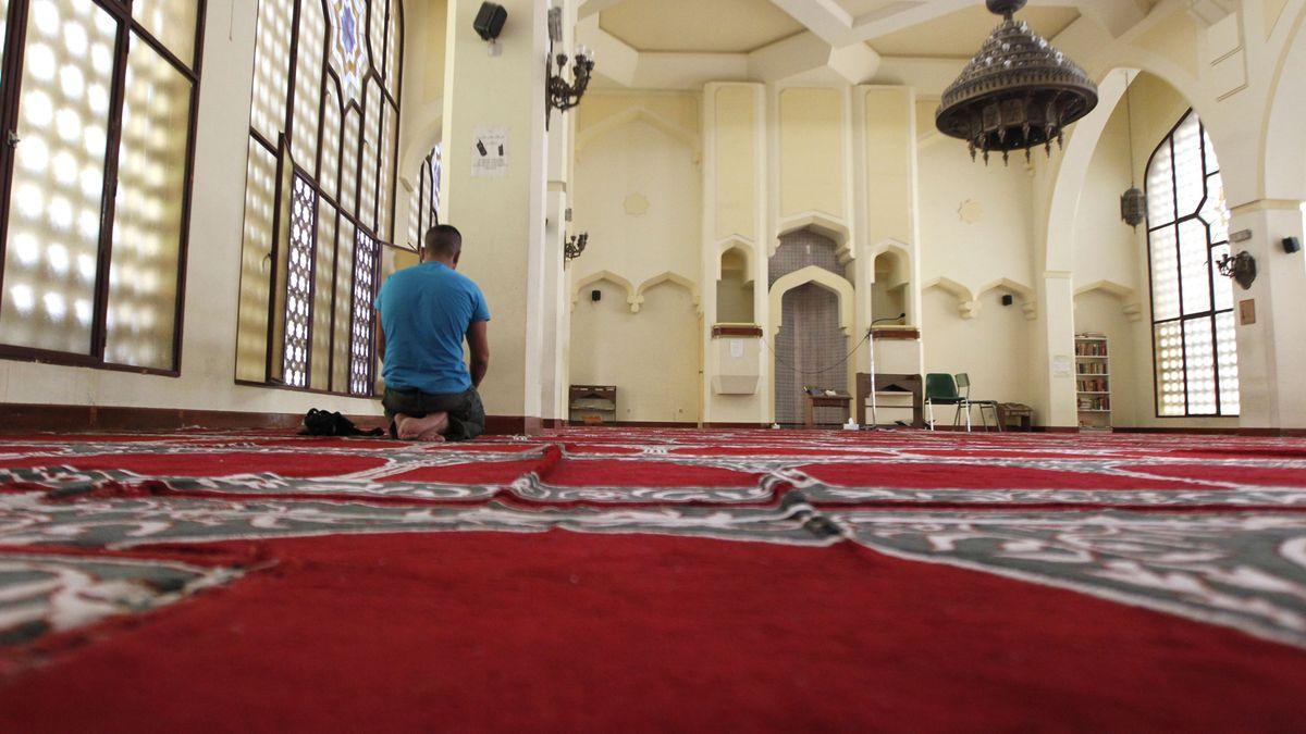 Un hombre reza en una mezquita.