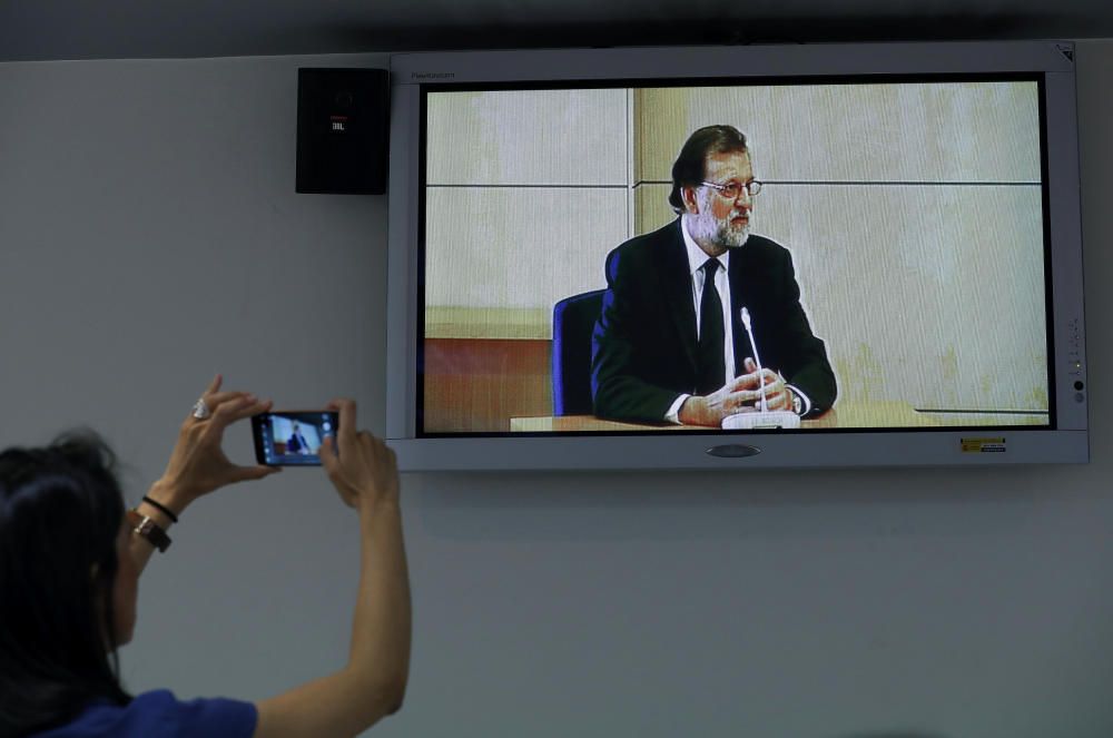 A journalist photographs the screen of a press ...