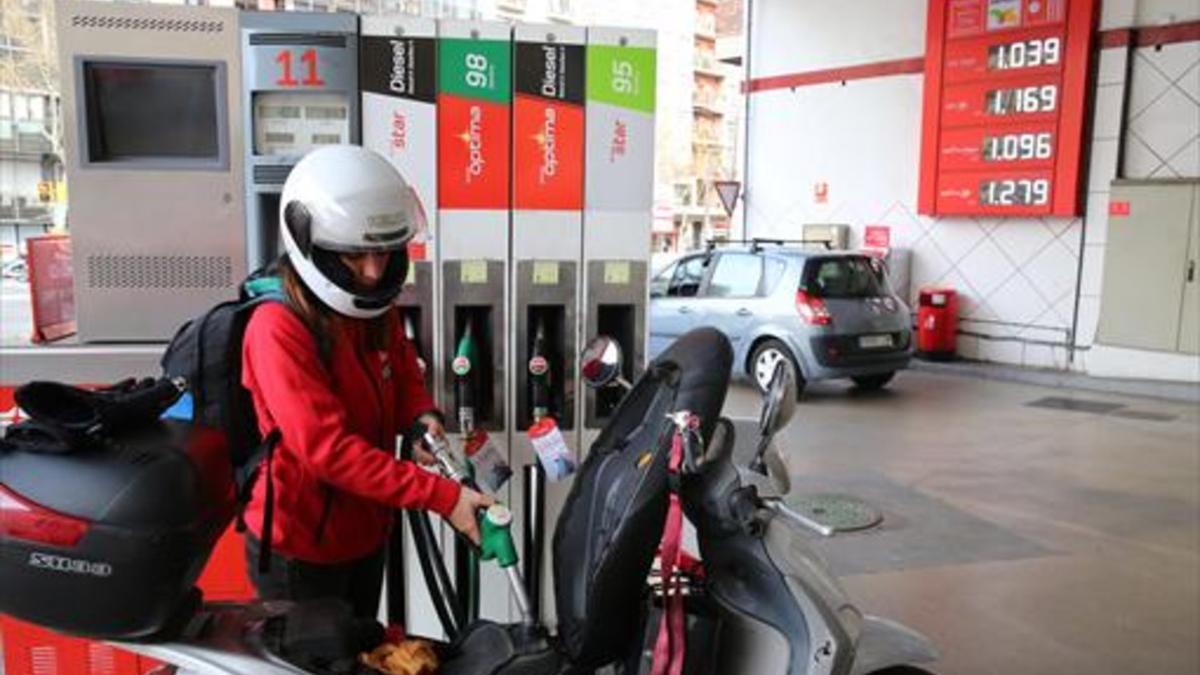 Una joven reposta carburante para su moto en una gasolinera del Paral·lel, el martes.