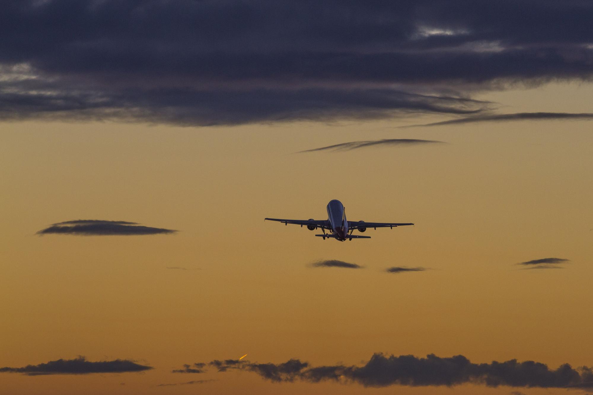 Avión despegando del aeropuerto de Ibiza con la puesta de sol.