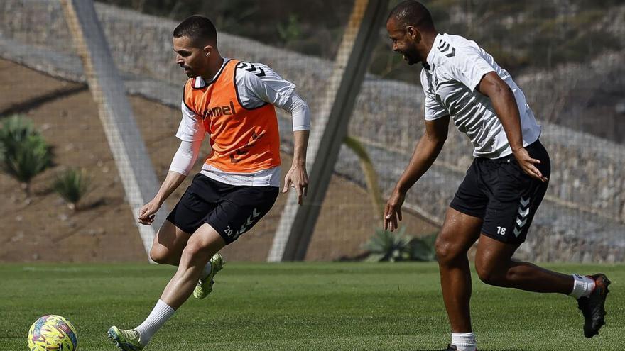 Kirian Rodríguez golpea el balón perseguido por Sidnei durante el entrenamiento de ayer en Barranco Seco. | | LP/DLP