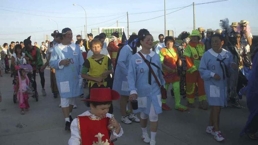 Vecinos participan en el desfile de carnaval de verano de las fiestas.