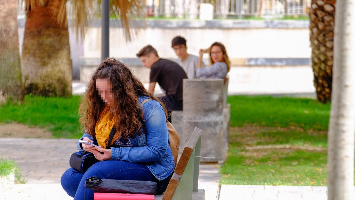 Una joven navegando por internet en la plaza Castelar de Elda.