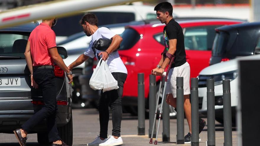 Rafa Barber, uno de los agentes de Soler, ayuda al jugador a entrar en el coche, ayer en Paterna.