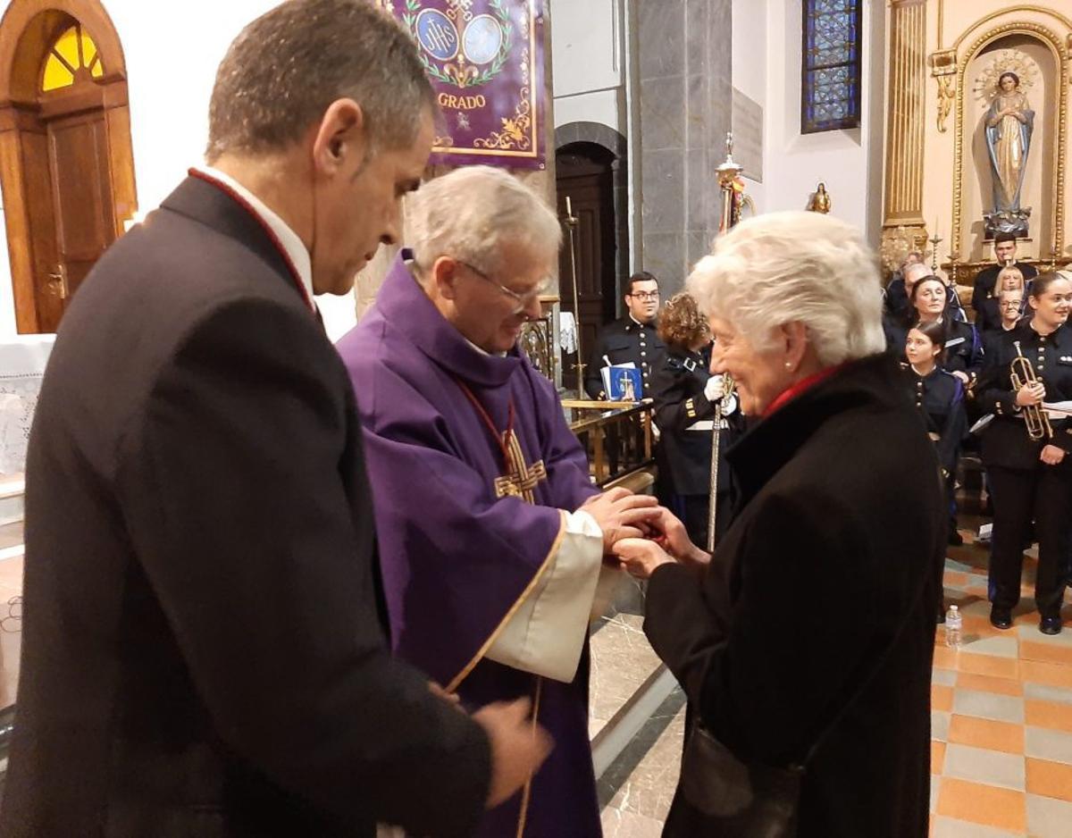 A la izquierda, Amelia Fidalgo es admitida en la cofradía por Ramón González y el párroco Reinerio García. A la derecha, Sofía Pravia, con su medalla.