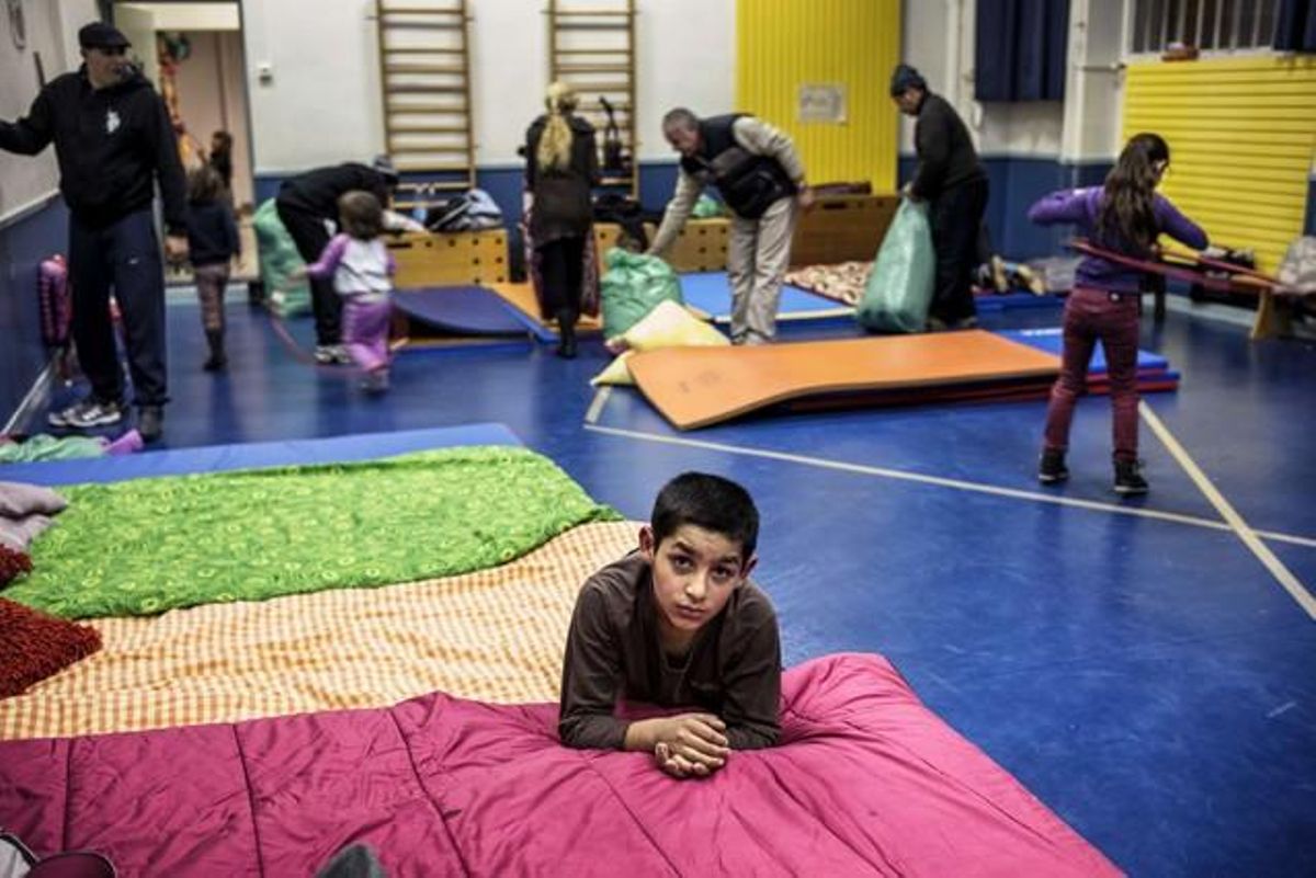 Un niño en el gimnasio de una de las escuelas de Lyon ocupadas por la oenegé Nunca Sin Techo.