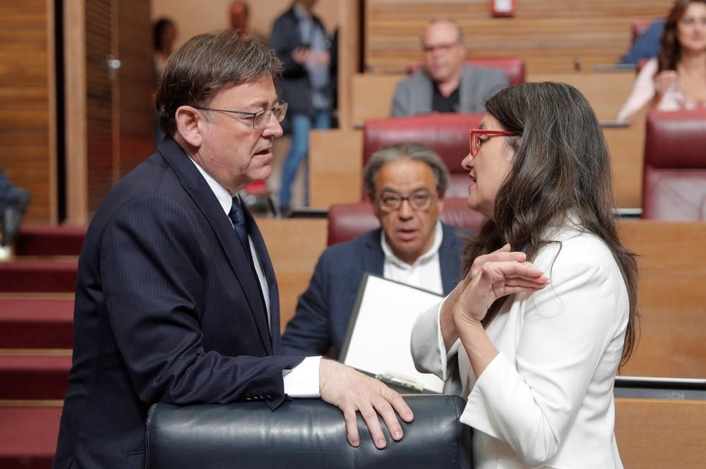 El president de la Generalitat en funciones, Ximo Puig, conversa con la vicepresidenta en funciones, Mónica Oltra, a su llegada al pleno