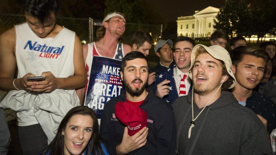 Jóvenes seguidores de Trump cantan el himno nacional.