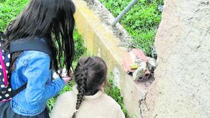 Dos niñas encuentran una de las rocas junto a una valla. | Cedida