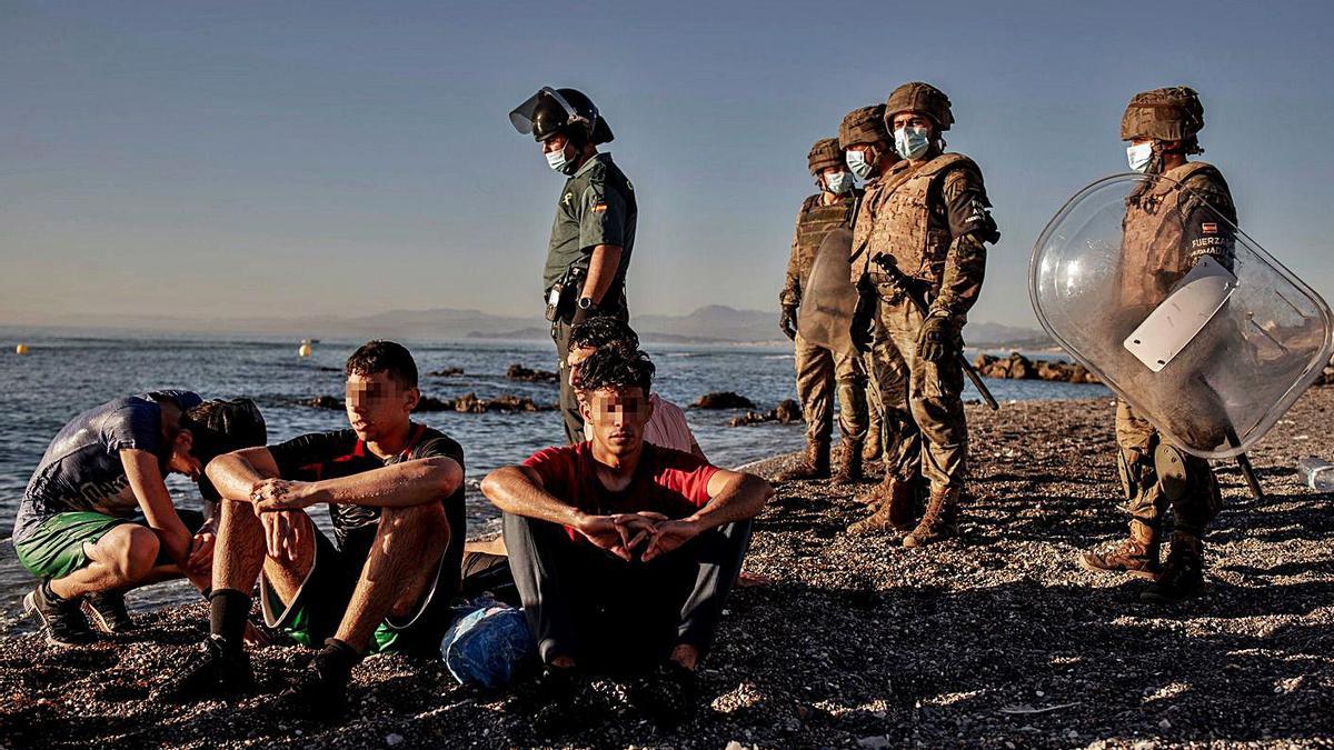 Miembros del Ejército observan en Ceuta a un grupo de menores llegados de Marruecos.