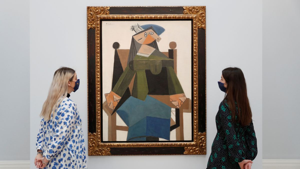 Trabajadores de Sotheby's observan 'Femme Assise Dans Un Fauteuil', de Pablo Picasso.