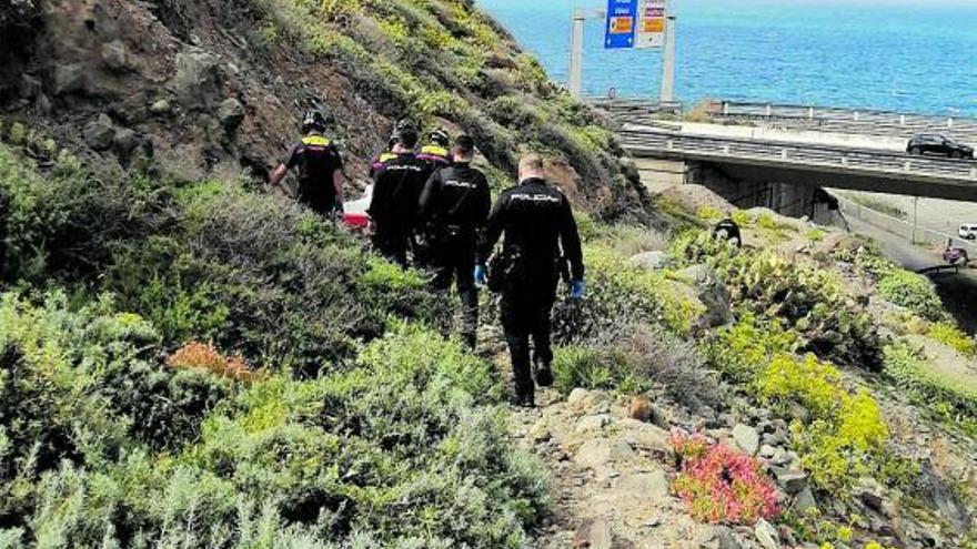 Bomberos del parque de La Isleta y agentes de la Policía Nacional durante el traslado del cadáver ayer en El Rincón. | | ED