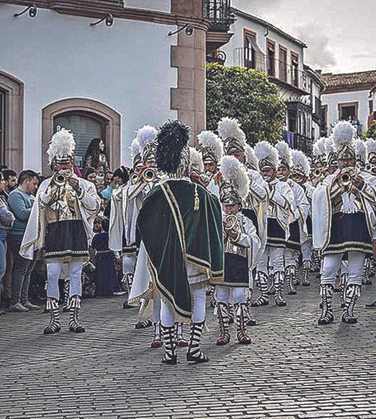 Desfile marcial sobre el suelo adoquinado.
