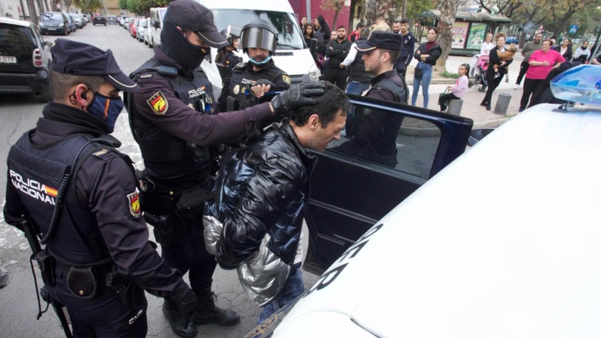 Uno de los detenidos entra en el coche policial.