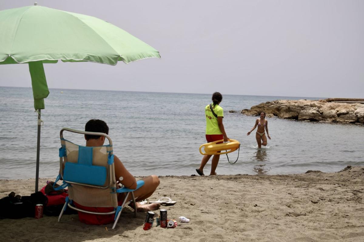 Un socorrista se dirige a una bañista este jueves en la playa de Pedregalejo.