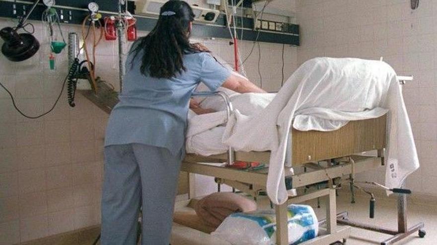 Una auxiliar d&#039;infermeria mou un pacient en un hospital