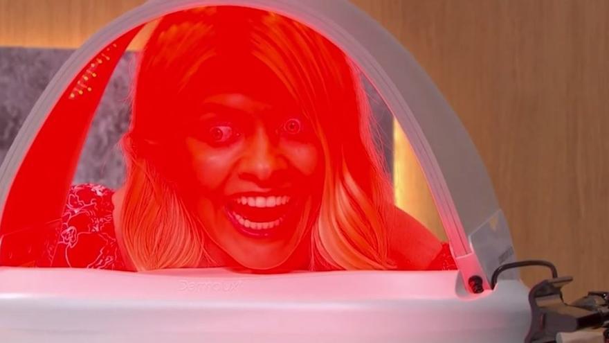 Una mujer probando el aparato doméstico de fototerapia LED que triunfa entre las famosas