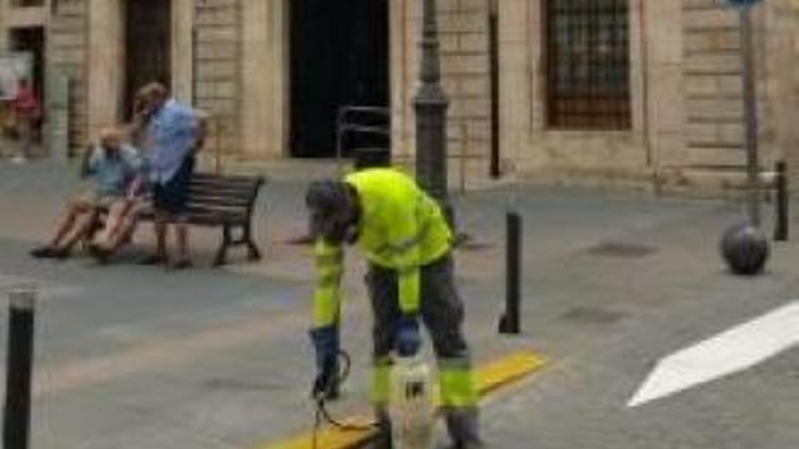 Un operario limpia el alcantarillado en el casco de Sueca.