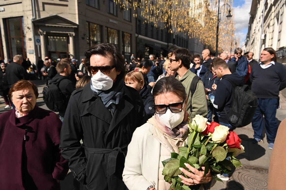 Una mujer sostiene flores mientras hace cola para asistir a una ceremonia de despedida frente al edificio de la Sala de las Columnas, donde se lleva a cabo una ceremonia de despedida del último líder de la Unión Soviética y ganador del Premio Nobel de la Paz en 1990, Mikhail Gorbachev.